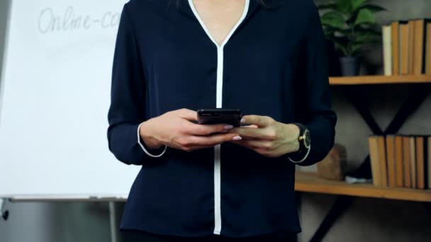 Mujer de negocios sosteniendo el teléfono en las manos escribiendo un mensaje en las redes sociales — Vídeos de Stock