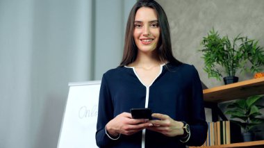 Güzel gülümseyen öğretmen koç el ele tutuşup ofiste kameraya bakıyor.