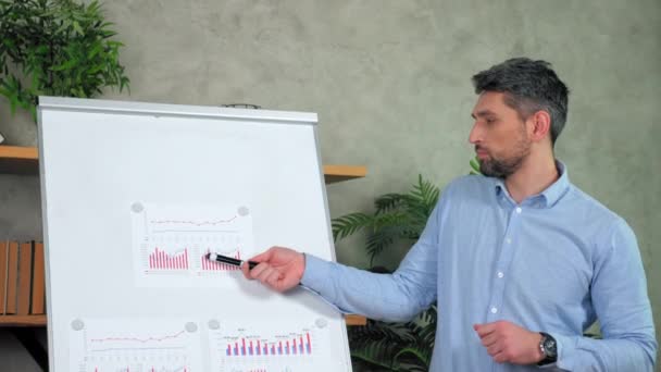 Homme confiant enseignant point marqueur diagramme sur flip chart en ligne enseigne aux élèves — Video