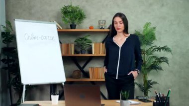 Acele et, iş kadını online rapor laptopunu dinliyor, saati gösteriyor.