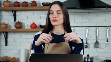 Önlüklü düşünceli kadın ev hanımı çözüm sorununu ev mutfağında düşünüyor.