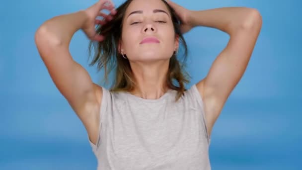 Vacker kvinna i grå t-shirt lyssnar på musik, dansar och njuter av ljudet — Stockvideo