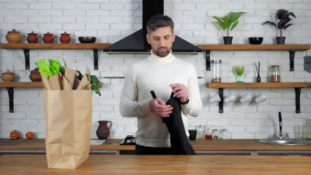 Chef barbudo homem em camisola branca vem para casa cozinha coloca em avental preto — Vídeo de Stock