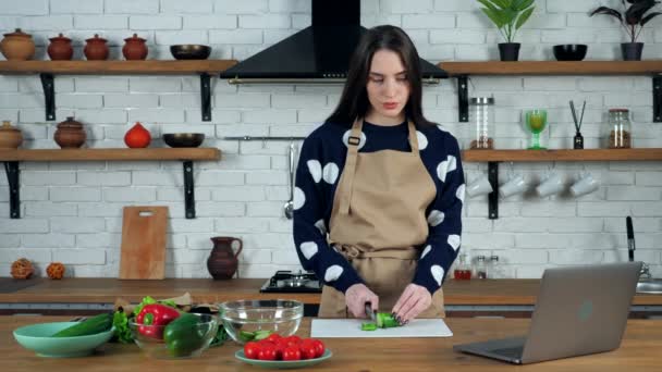 Dona de casa escuta professor chef estudo on-line chamada de vídeo cortado pepino fresco — Vídeo de Stock