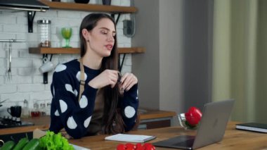 Ev hanımı internetteki webcam görüntülü arama laptopunu inceliyor.