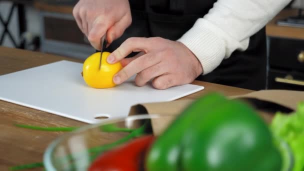 Manos chef hombre en delantal de pie cerca de la mesa corta limón a bordo en la cocina casera — Vídeos de Stock