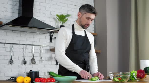 Muž šéfkuchař jídlo blogger krájené okurky v kuchyni učí online videokall webkamera — Stock video