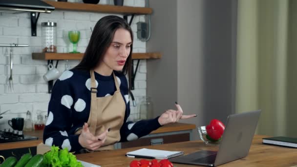 Emotional woman housewife tells chef teacher online video call laptop in kitchen — Stock Video