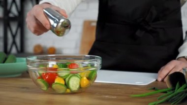 Aşçı başı mutfaktaki cam kasede tuzlu vejetaryen salatasının yanında duruyor.