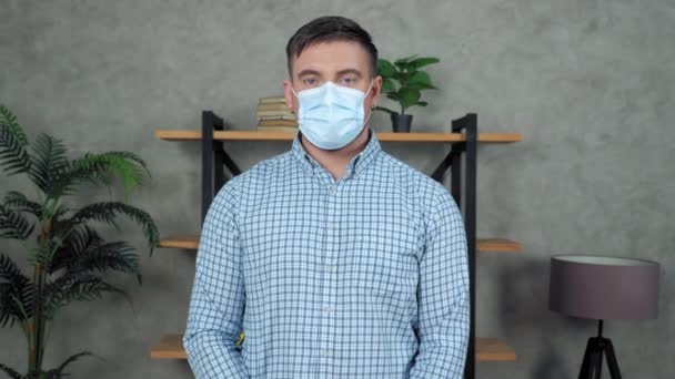 사업가는 얼굴을 돌려 얼굴을 가리고 의료용 마스크를 쓰고 있다 — 비디오