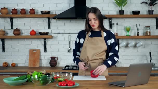 Сміється красива жінка ріже пілінг свіжого червоного болгарського перцю на обробній дошці — стокове відео