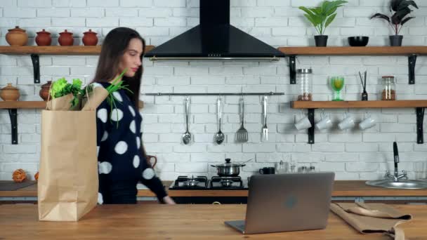 Γυναίκα σεφ δάσκαλος έρχεται στο σπίτι κουζίνα βάζει σε μπεζ ποδιά προετοιμάσει διδάσκει σε απευθείας σύνδεση μάθημα μαγειρικής webinar στο φορητό υπολογιστή — Αρχείο Βίντεο
