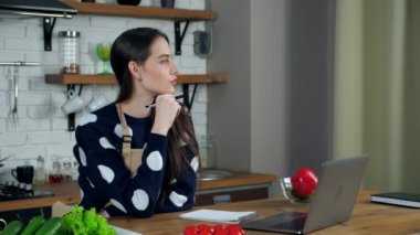 Düşünceli kadın, vejetaryen menüsünün yemek tarifini deftere yazdığını düşünüyor.