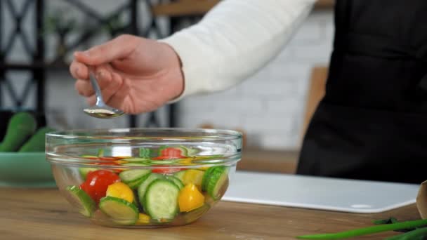 Chef de mano espolvorear semillas de sésamo en ensalada vegetariana cocida en un tazón de vidrio — Vídeos de Stock