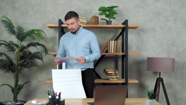 Zakenman loopt in kantoor met blad van diagram in de hand denken oplossing probleem — Stockvideo