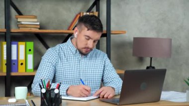 Düşünceli iş adamı defterine sorunlu çözüm performansı hakkında yazıyor.