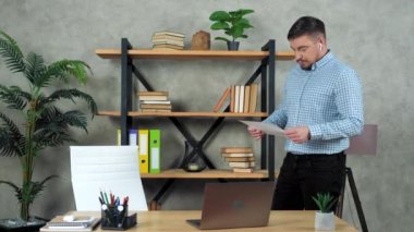 Elinde diyagramlar olan adam finansal analist çözüm sorununu düşünüyor