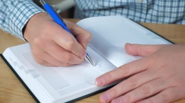 Kapalı işadamları, ev ofisteki defter çalışmalarına yapılacaklar listesi yazıyorlar.