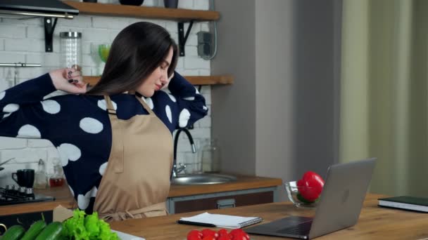 Mujer cansada escribe receta culinaria en el cuello masajes portátil después de usar el ordenador portátil — Vídeo de stock