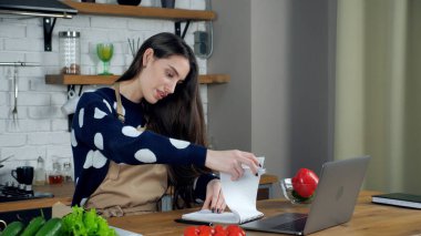 İnternette çalışan kadın bilgisayarına göre şef aşçı tarifi defteri.