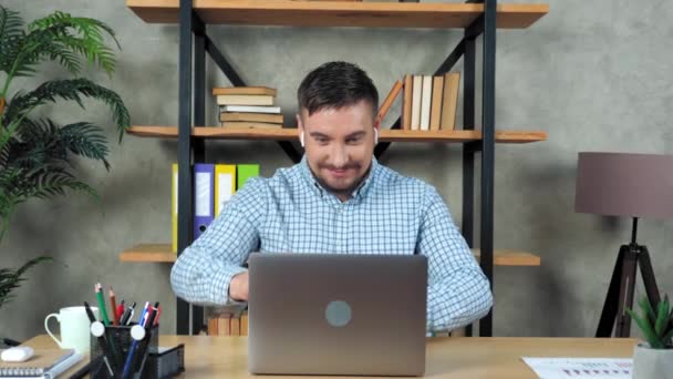 Smiling teacher man sitting on chair at desk in home open and start using laptop — Stock Video