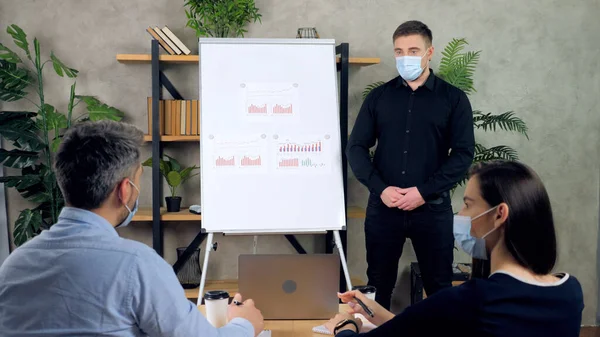 Man and woman in protective medical face mask work in office, business meeting