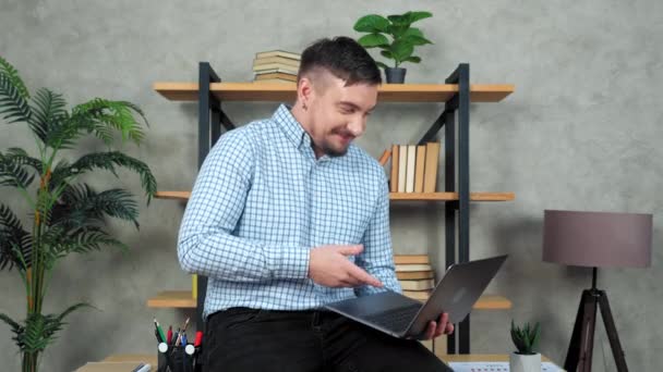 Γελώντας γενειοφόρος επιχειρηματίας κάθεται στο γραφείο κρατά φορητό υπολογιστή στο γραφείο στο σπίτι — Αρχείο Βίντεο