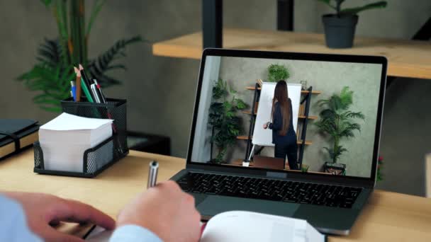 Empresario escribe en cuaderno, estudio reloj negocio curso en línea webcam portátil — Vídeos de Stock