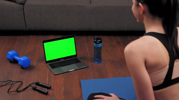 Green-Screen-Laptop-Konzept: Sportliche Frau in Sportbekleidung sitzt auf Yogamatte — Stockvideo