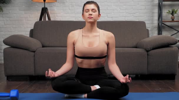 Close up rustige sportieve vrouw in sportkleding praktijken yoga thuis in slaapkamer — Stockvideo