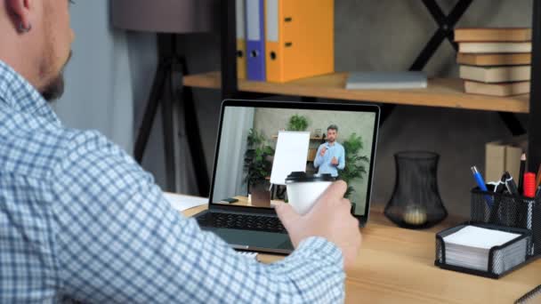 Empresário no escritório parece laptop ouvir curso de negócios on-line beber café — Vídeo de Stock