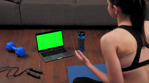 Green screen laptop koncept: Atletisk kvinna i sportkläder sitter på yogamattan — Stockvideo