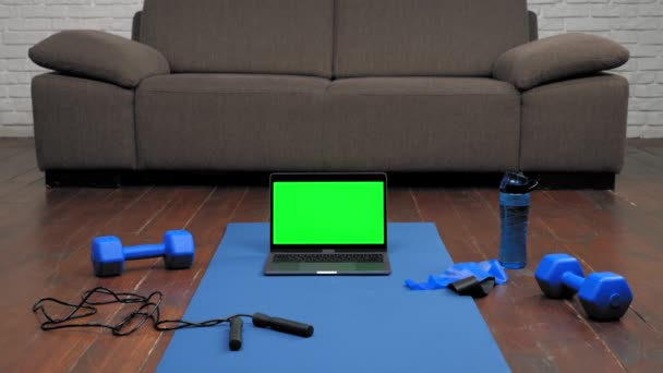 Display per computer portatile stand schermo verde su fitness o tappetino yoga su sfondo divano casa — Video Stock