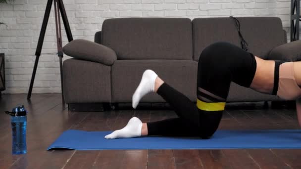 Atlética chica muscular deportista hace ejercicio para las nalgas con banda de lazo — Vídeos de Stock