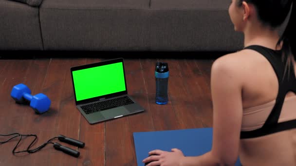 แนวคิดแล็ปท็อปหน้าจอสีเขียว: ผู้หญิงดูคอมพิวเตอร์พูดคุยฟังครูฝึกฟิตเนส — วีดีโอสต็อก