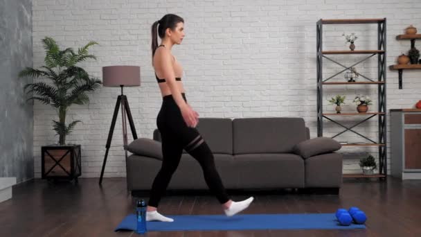 Fit mujer en ropa deportiva hace ejercicios deportivos en fitness o yoga estera en casa — Vídeo de stock