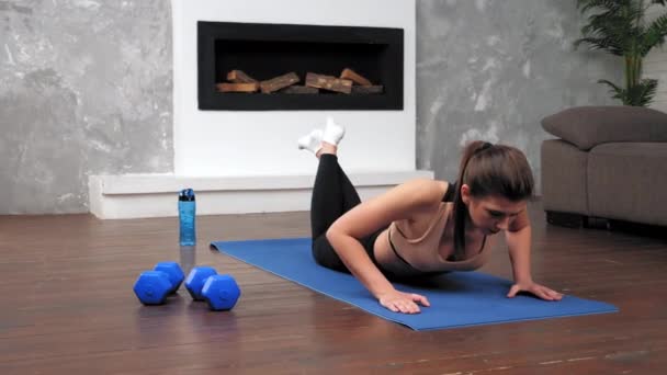 Sterke fit vrouw in sportkleding doet push-up oefening op fitness yoga blauwe mat — Stockvideo