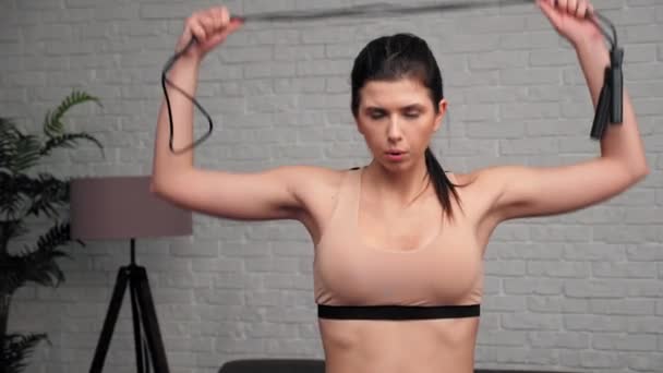 Portrait athletic muscular tired woman looking camera with jumping-rope at home — Stock Video