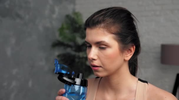 Sportovní žena pije vodu z po aktivním fitness cvičení doma — Stock video