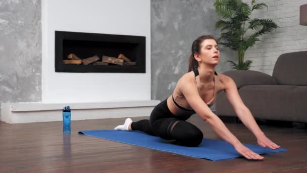 Fit mujer en ropa deportiva hace ejercicios deportivos en fitness o yoga estera en casa — Vídeos de Stock