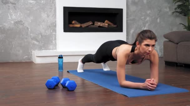 Sterke fitnessvrouw in sportkleding die planktraining doet op fitnessyogamat — Stockvideo