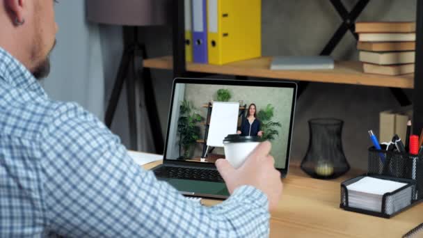 Homme d'affaires au bureau regarde ordinateur portable écouter webinaire d'affaires en ligne, boire du café — Video