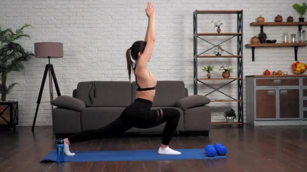 A sportszerkós nő otthon sporttevékenységeket végez fitnesz vagy jóga matracon. — Stock videók