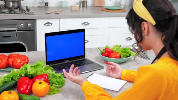 Блакитний екран ноутбук: жінка дивиться онлайн курс приготування вебінар розповідає вчительку шеф-кухаря — стокове відео
