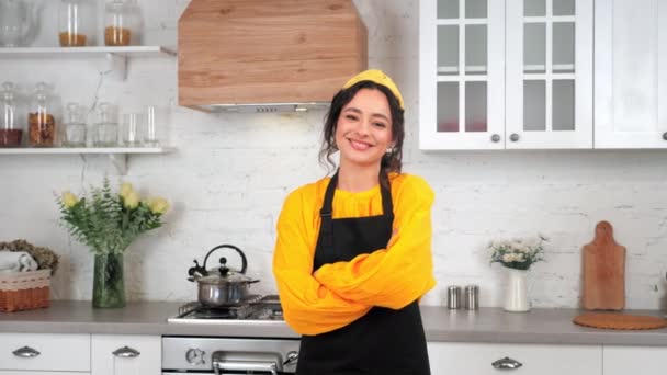 Portrait smiling housewife turns head and crossing hands in home modern kitchen — Stock Video