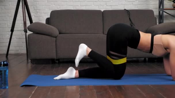 Mujer en ropa deportiva hace ejercicio de entrenamiento deportivo en colchoneta de yoga fitness en casa — Vídeos de Stock