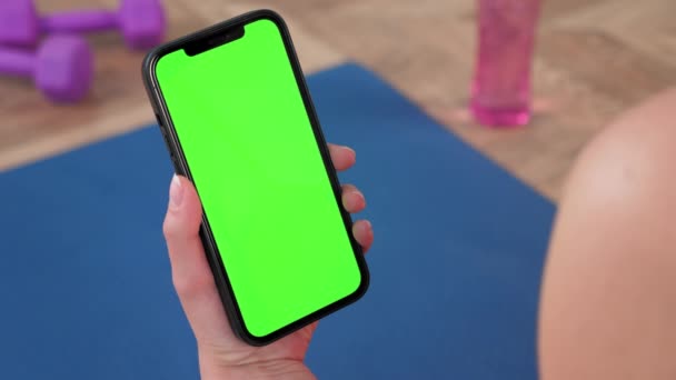 Groene scherm smartphone: Close-up smartphone in de hand ziet er groen isoleren display — Stockvideo