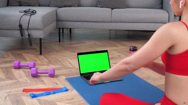 Ordinateur portable à écran vert : Fit femme regarde ordinateur dit entraîneur de fitness vidéo en ligne — Video