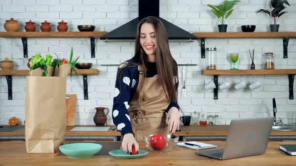 Glimlachende vrouw pakt ingrediënten uit papieren zak zet kerstomaat op kom — Stockfoto