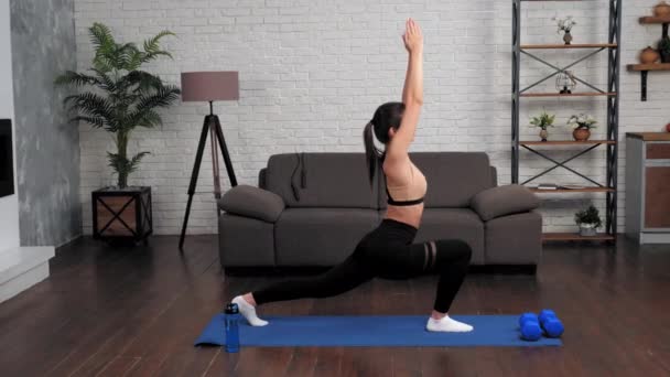 Fit vrouw in sportkleding doet sport oefeningen op fitness of yoga mat thuis — Stockvideo